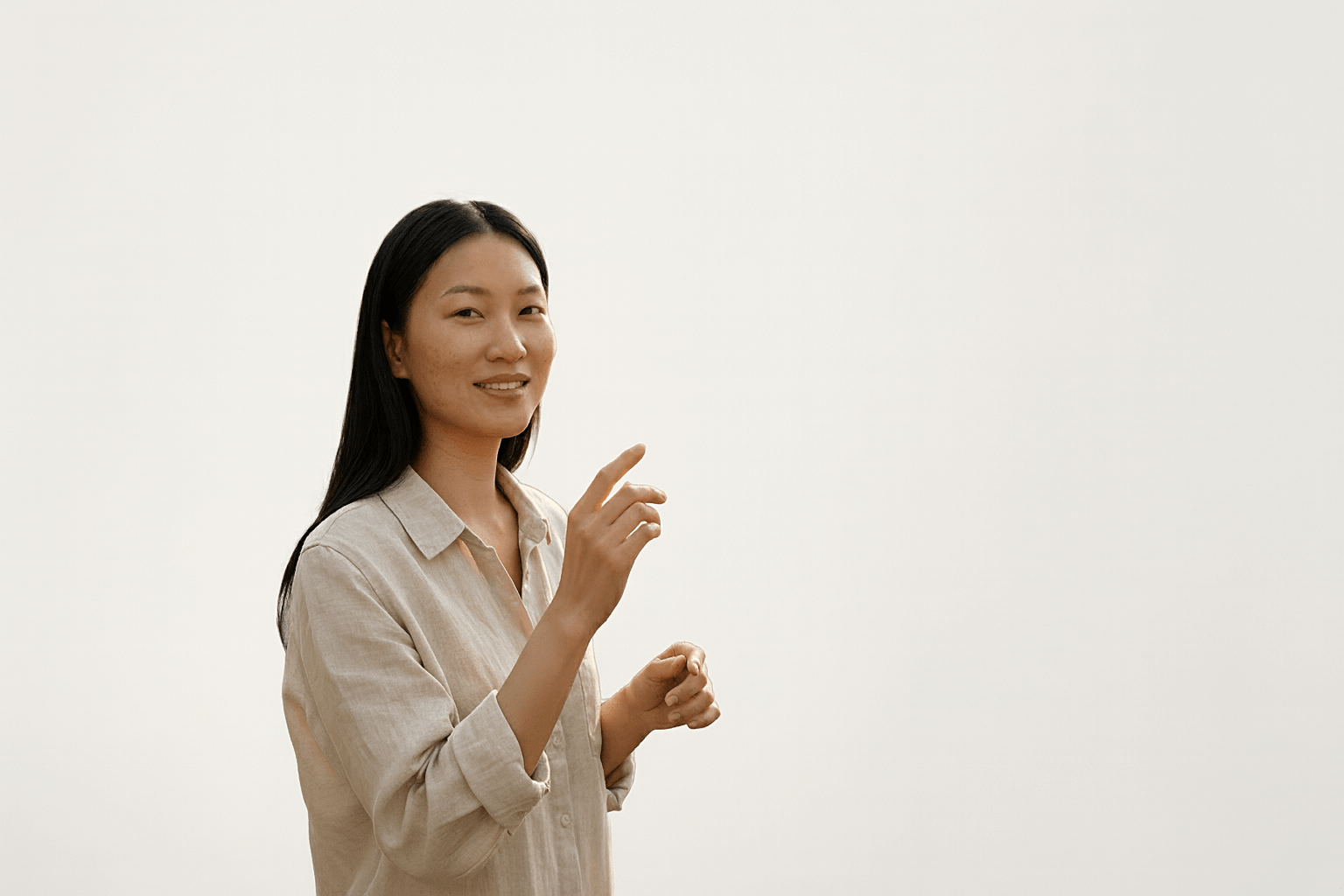 Vrouw met een rustige huid die een natuurlijke skincare handbeweging maakt in een zachte studiosetting