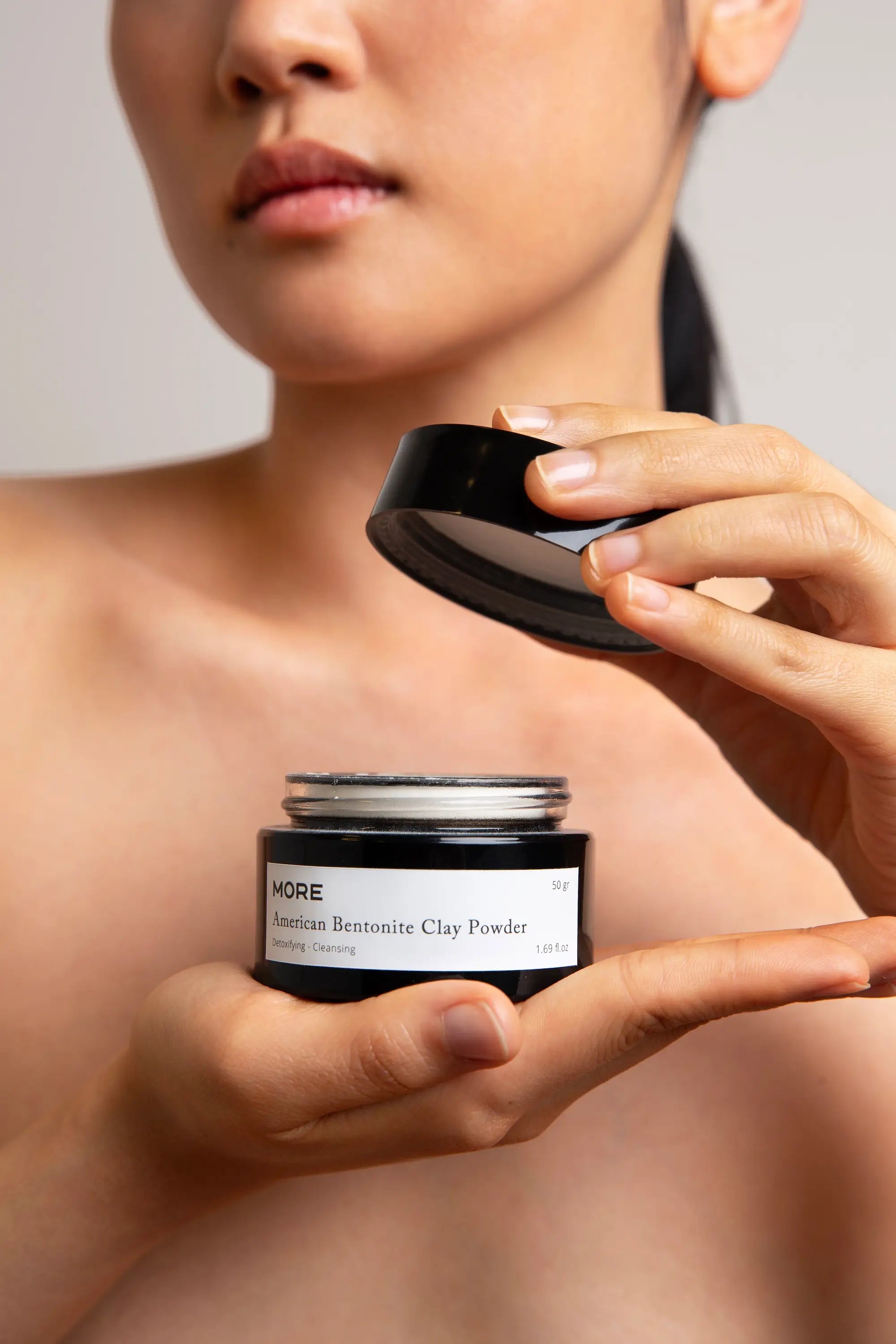 Model opent verpakking van American Bentonite Clay Powder